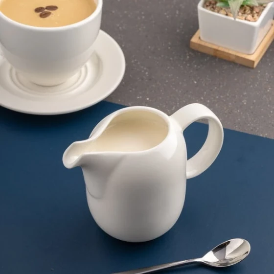 Ariane Vital Coupe 8.44 oz. Warm White Porcelain Creamer with Handle - 6/Case