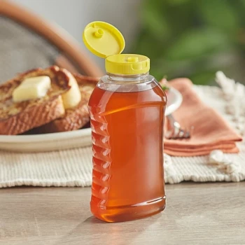 11 oz. (16 oz. Honey Weight) Ribbed Hourglass PET Honey Bottle with Pressure Sensitive Liner Yellow Plastic Flip Top Lid - 295/Case