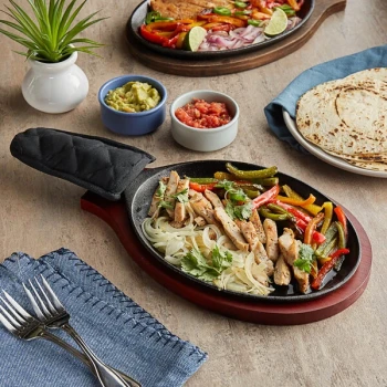 Choice 9 1/4" x 7" Oval Pre-Seasoned Cast Iron Fajita Skillet with Mahogany Finish Wood Underliner and Black Cotton Handle Cover