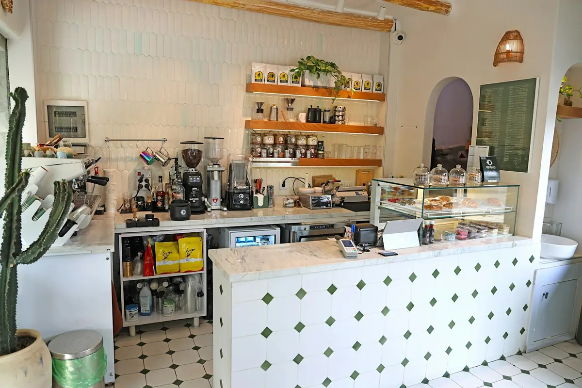 Café counter with an espresso machine, grinders and a pastry display