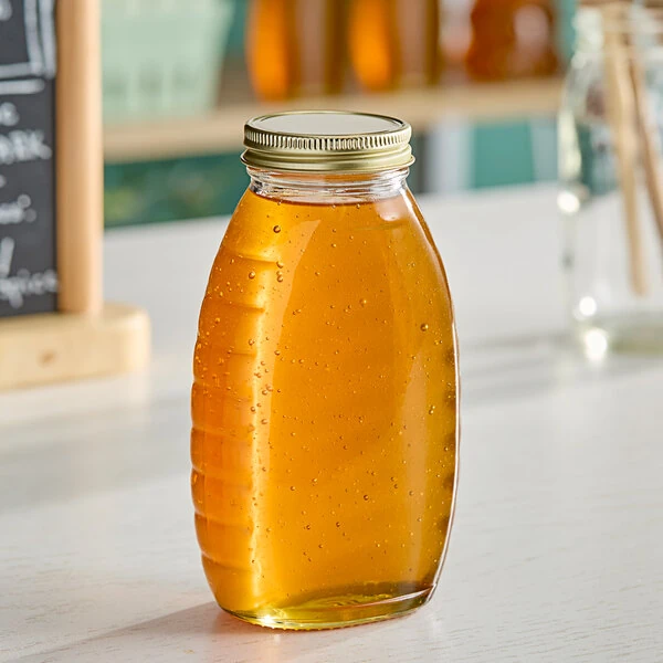 12 oz. (16 oz. Honey Weight) Classic Queenline Glass Honey Jar with Plastisol-Lined Gold Metal Lid - 96/Case