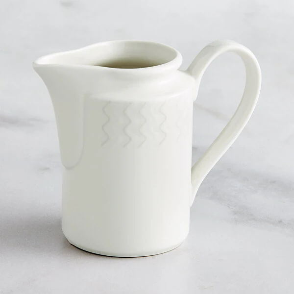 RAK Porcelain Leon 8.5 oz. Ivory Embossed Porcelain Creamer - 6/Case