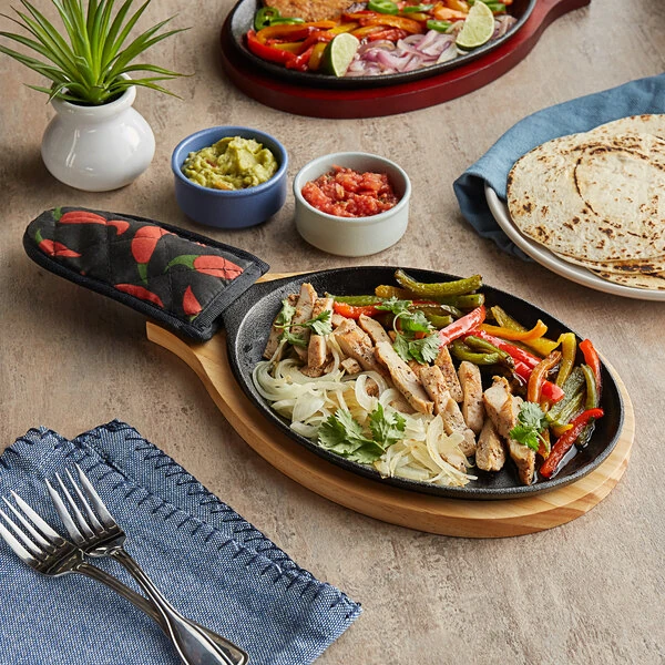 Choice 9 1/4" x 7" Oval Pre-Seasoned Cast Iron Fajita Skillet with Natural Finish Wood Underliner and Chili Pepper Cotton Handle Cover