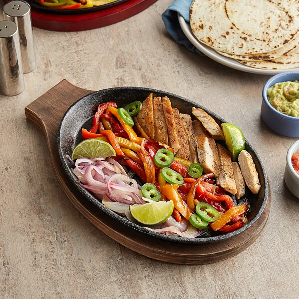 Choice 9 1/4" x 7" Oval Pre-Seasoned Cast Iron Fajita Skillet with Oak Finish Wood Underliner
