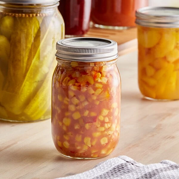 Choice 16 oz. Pint Regular Mouth Glass Canning / Mason Jar with Silver Metal Lid and Band - 12/Case