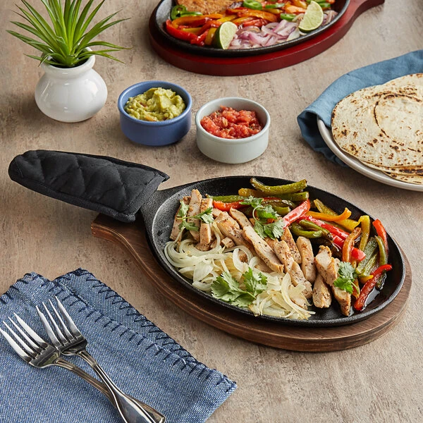 Choice 9 1/4" x 7" Oval Pre-Seasoned Cast Iron Fajita Skillet with Oak Finish Wood Underliner and Black Cotton Handle Cover