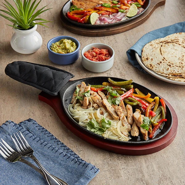 Choice 9 1/4" x 7" Oval Pre-Seasoned Cast Iron Fajita Skillet with Mahogany Finish Wood Underliner and Black Cotton Handle Cover